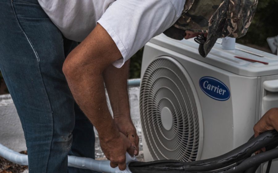Technician repairing a residential central air conditioner